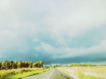 Empty road along countryside landscape