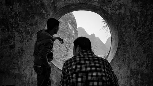 Rear view of men standing in tunnel