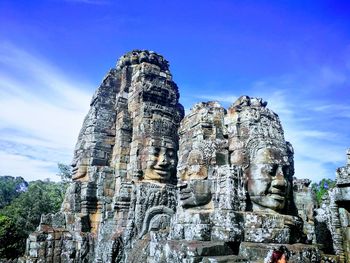 Old ruin temple with buddha carvings against blue sky