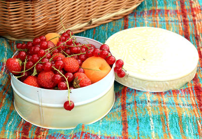 Round white tin with berries and apricots 