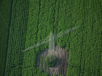 High angle view of electricity pylon on green farm field