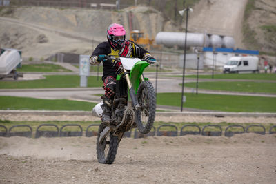 Man doing stunt with motorcycle on dirt road