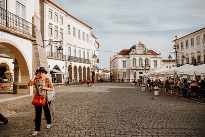 People walking on street amidst buildings in city