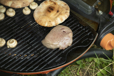 Cropped hand of person preparing food on barbecue grill