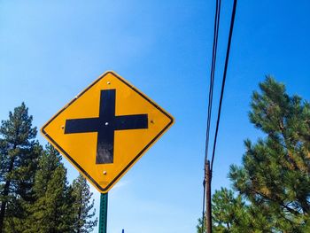 Low angle view of road sign against blue sky