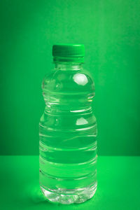 Close-up of glass bottle against green background