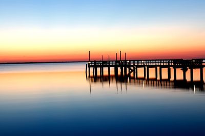 Silhouette pier on sea against sky during sunset