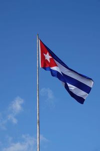 Low angle view of flag against blue sky