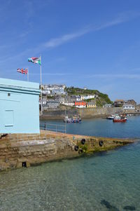 Scenic view of sea and buildings against blue sky