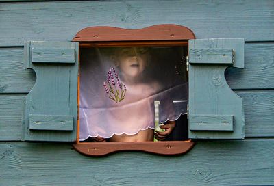 Portrait of a cute kid in a children's playhouse behind the curtain