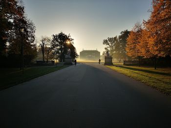 Road amidst trees against sky during autumn