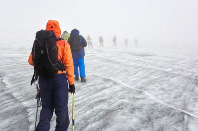 Rear view of backpackers ascending margherita glacier in the rwenzori mountains, uganda