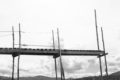 Low angle view of silhouette cranes against sky