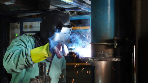 Man welding metal at workshop