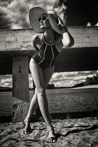 Portrait of young woman standing on wooden wall