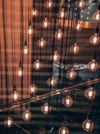 Low angle view of illuminated pendant lights hanging from ceiling