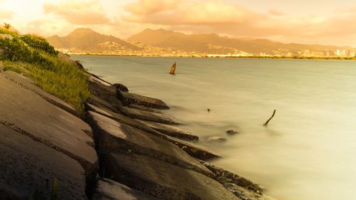 Scenic view of beach against cloudy sky