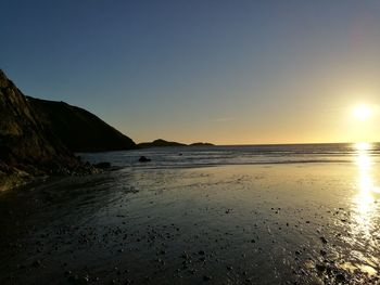 Scenic view of beach against sky during sunset