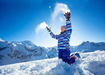 Low section of man skiing on snow covered mountain