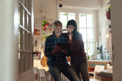 Smiling man sharing tablet pc at home