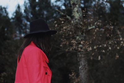 Rear view of woman standing against tree