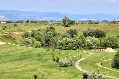 Scenic view of green field by mountains