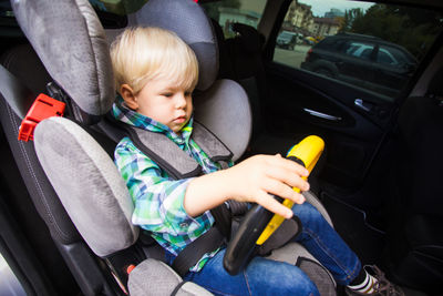 Cute boy sitting in car