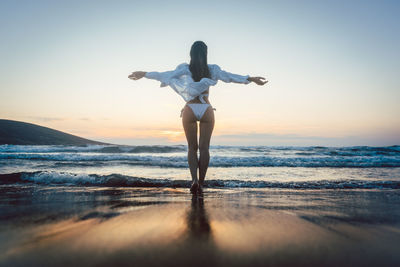 Full length rear view of man standing on beach