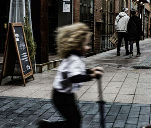 People walking on sidewalk in city