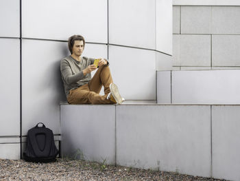 Portrait of young woman using mobile phone while sitting at home