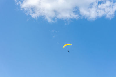 Low angle view of person paragliding against sky