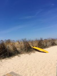 Scenic view of beach against clear blue sky