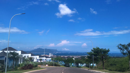 Street by road against blue sky