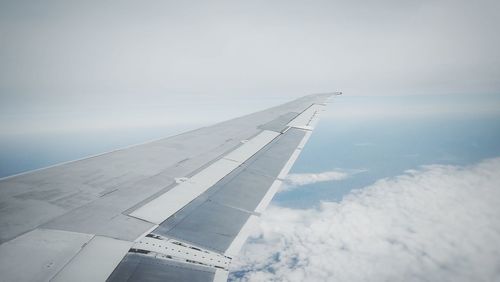 Airplane flying over clouds against sky