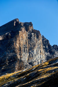 Aerial view of rocky mountains against clear blue sky