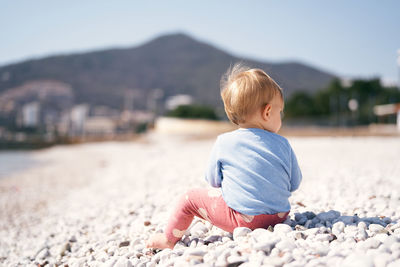 Cute boy on pebbles at beach
