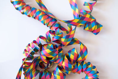 Close-up of colorful paper on white background during christmas