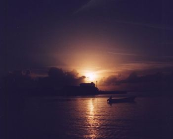 Silhouette of boats in sea at night