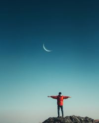 Full length of man standing against moon in sky