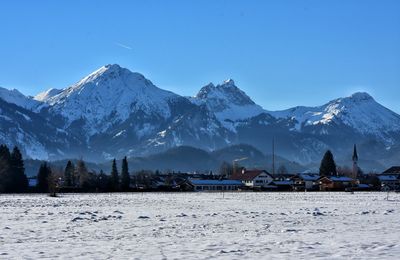 Scenic view of snowcapped mountains against clear blue sky