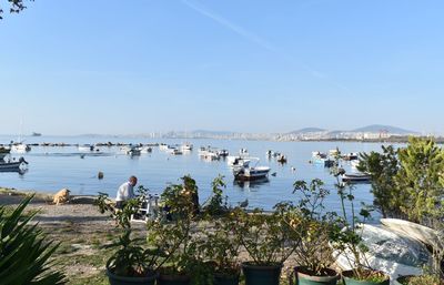 Boats moored in sea against blue sky
