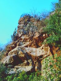 Low angle view of rocks against blue sky