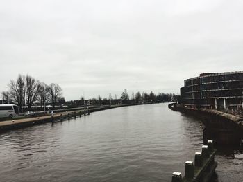 River amidst buildings in city against sky