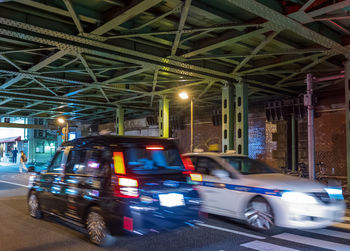 Cars on illuminated street at night