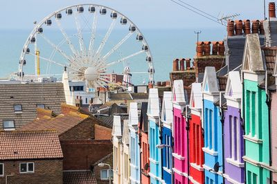 Ferris wheel and colorful buildings against sea