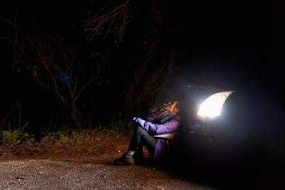 Man sitting in illuminated car at night