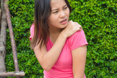 Midsection of woman with pink hair against plants