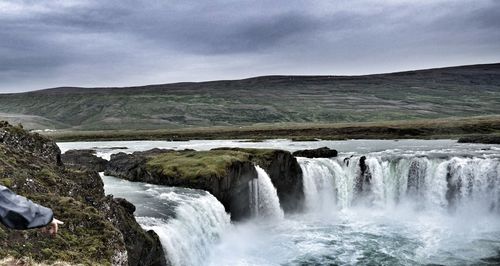 Scenic view of waterfall against sky