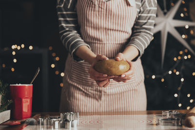 Midsection of woman holding ice cream on table