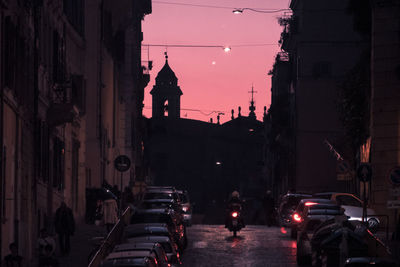 People walking on road amidst buildings in city at night